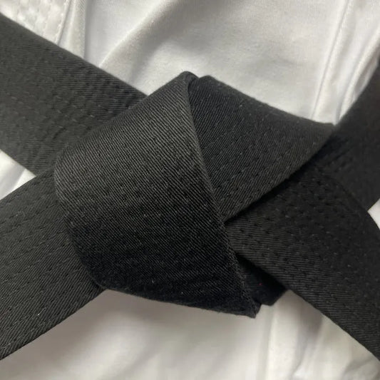 A close-up of a black martial arts belt tied in a knot.